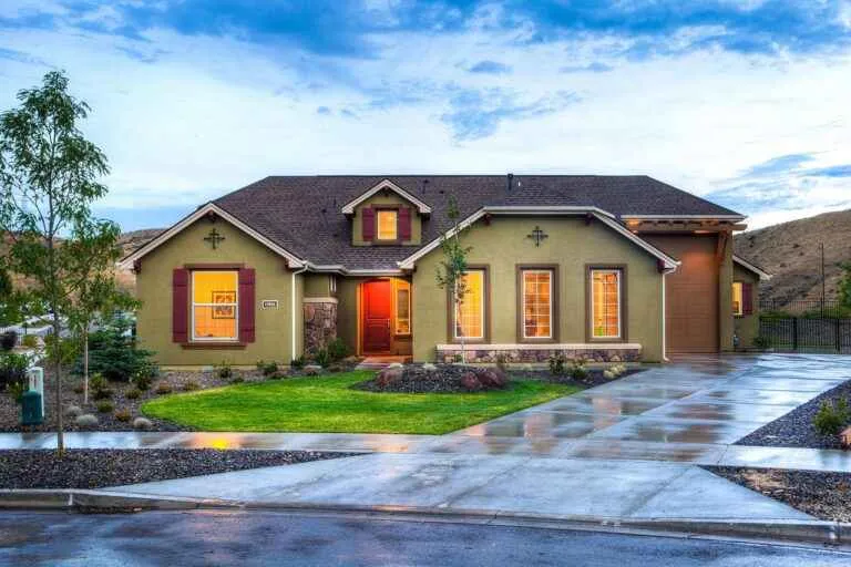 Residential concrete driveway with broom texture, control joints, and a connected front walkway