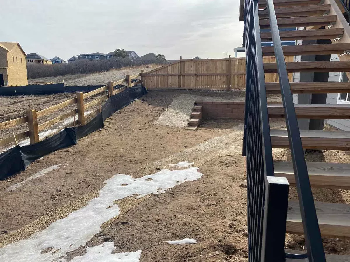 Sloped backyard with raw soil before landscape construction