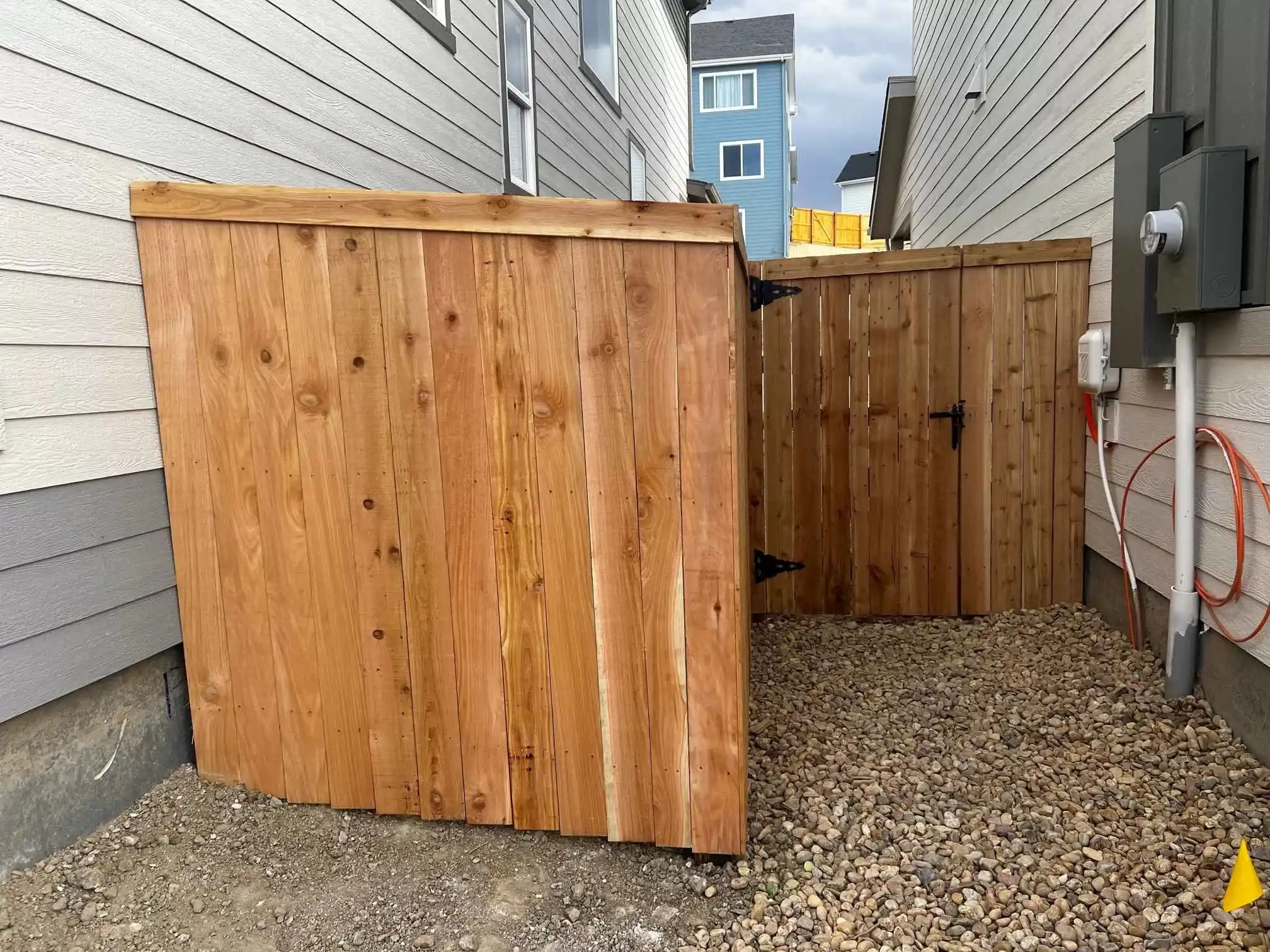 Residential fence installation beside a landscaped yard