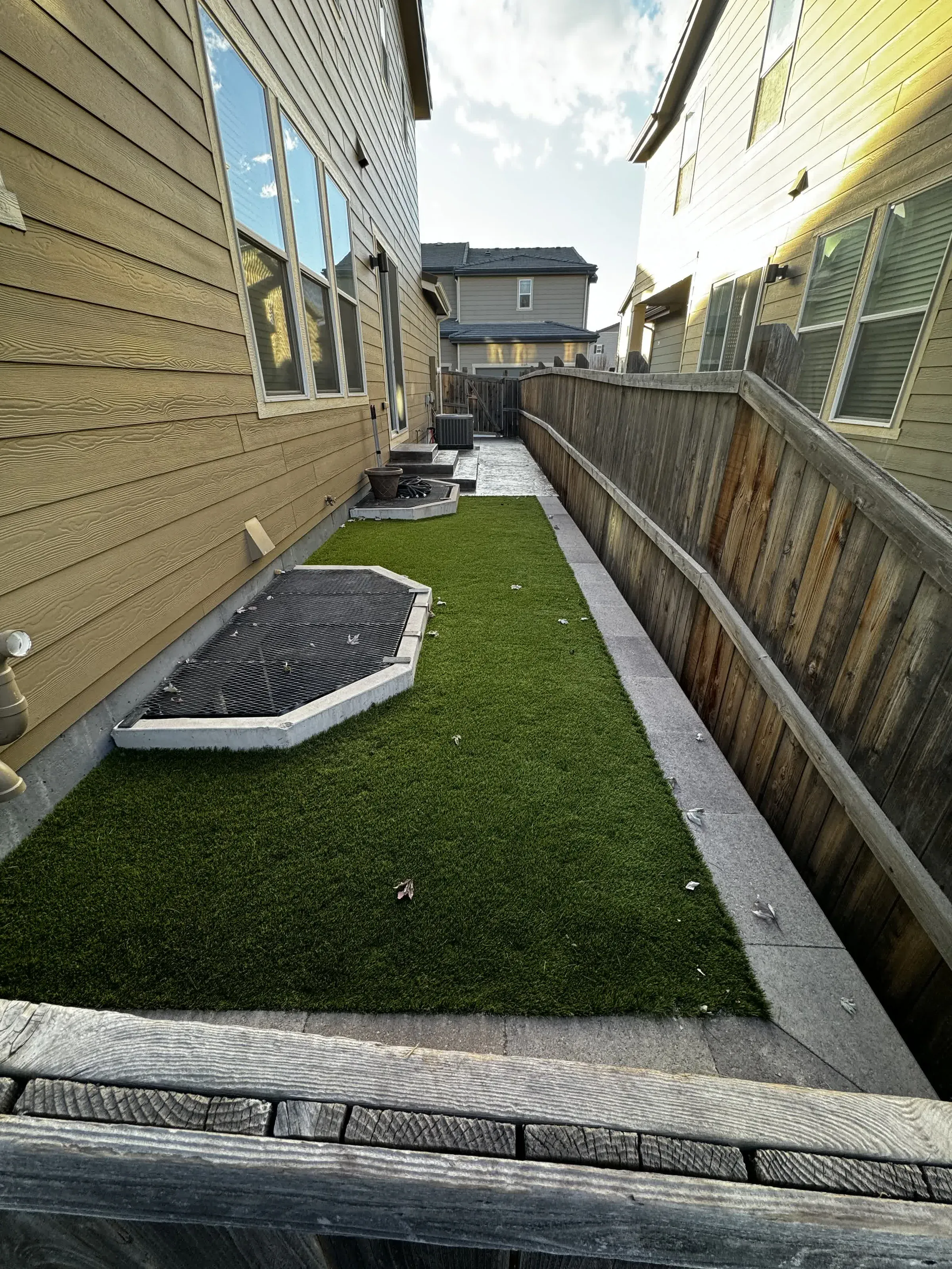Narrow side-yard artificial turf strip between two homes in Parker