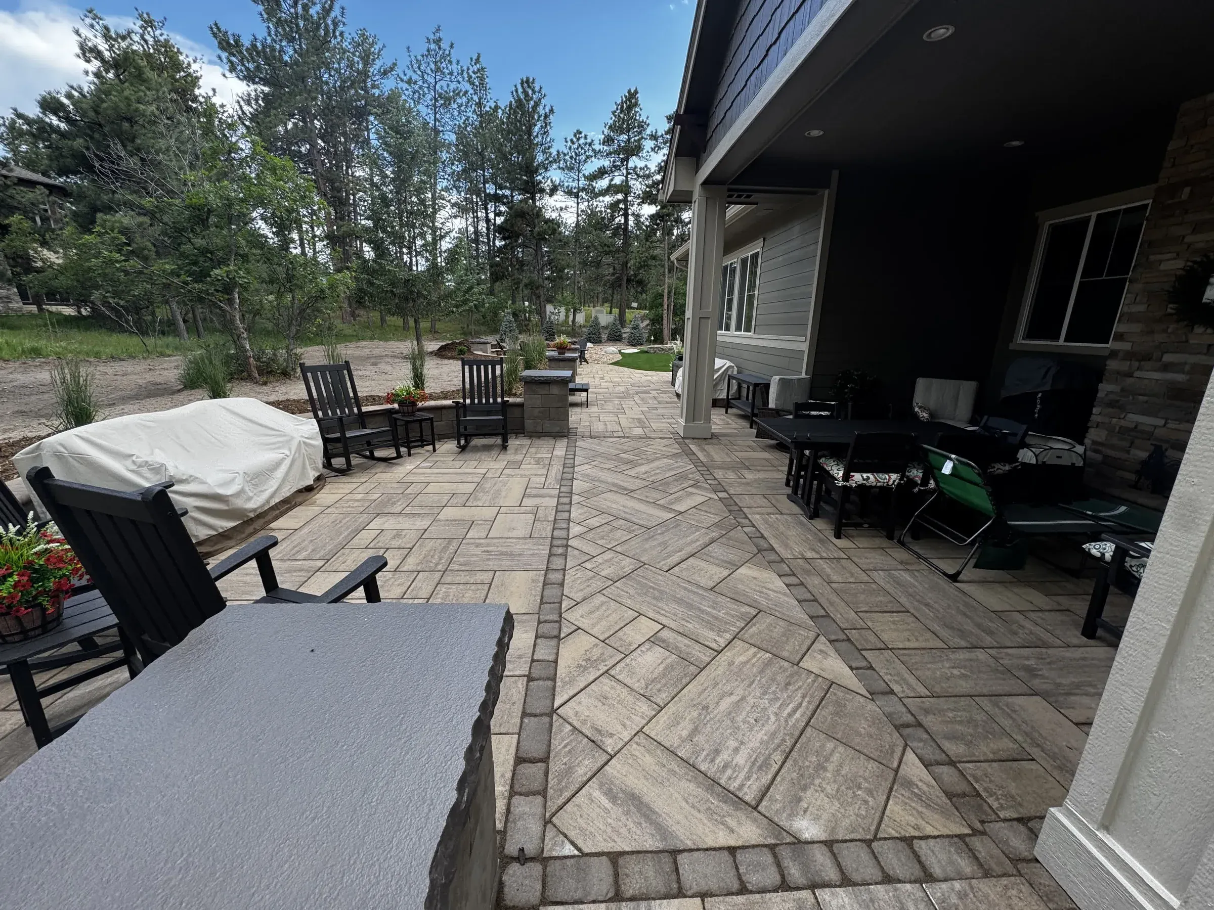 Covered paver patio with a herringbone pattern and outdoor dining and lounge seating in Larkspur