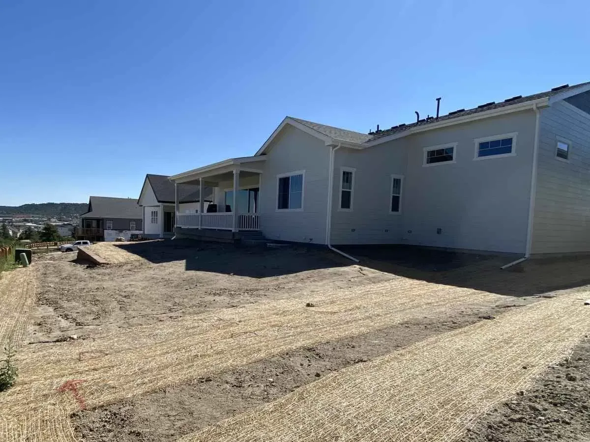 Bare yard with erosion-control material before landscape installation